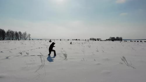 Woman Walks Through Snow Field