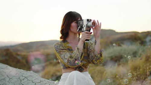 Young Woman Films Bubbles with Vintage Camera