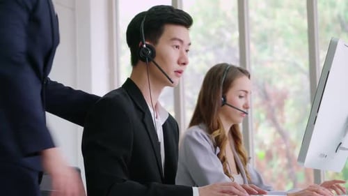 Geschäftsleute mit Headset, die im Büro arbeiten