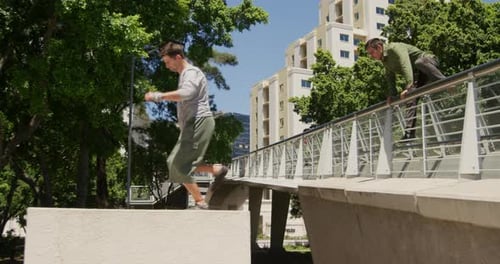 Men Practicing Parkour on Bridge in Urban Setting