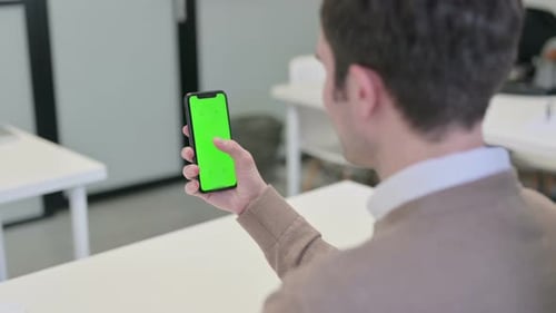 Rear View of Man Looking at Smartphone with Chroma Screen