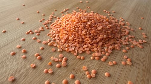 Vibrant Red Lentils Poured on Wooden Surface