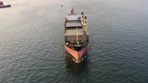 Cargo Rusty Ship Sails on the Sea at Sunset
