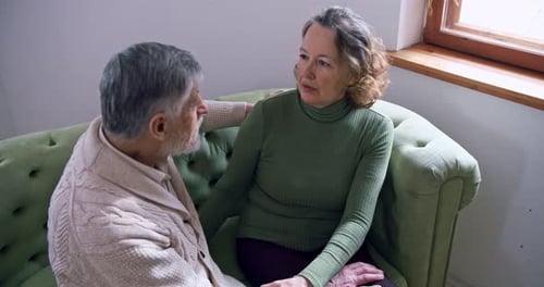 Senior Woman Talking with Senior Man on Couch