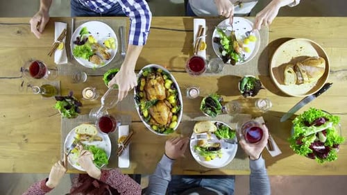Overhead Top View Table Four Caucasian Friends Eating Lunch Drinking Toast Together with Chickensala