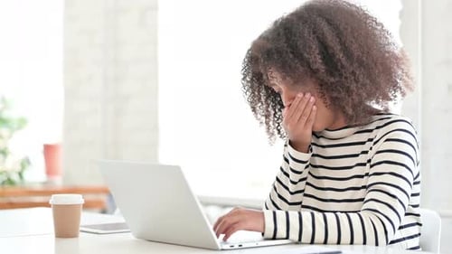 Woman Coughing While Working on Laptop at Home