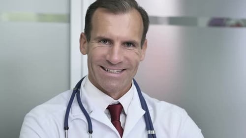 Smiling Male Doctor Close Up in Hospital Setting