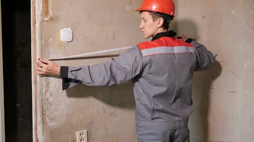 Man Measuring Concrete Wall Width