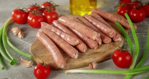 Raw Sausages with Tomatoes and Green Onions Slowly Rotate.