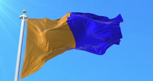 Waving Two Color Flag on Flagpole against Blue Sky