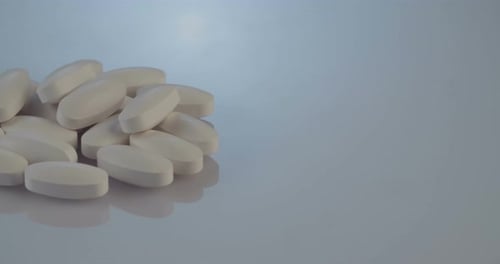 Pile of White Pills on Blue Background