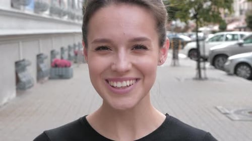 Young Woman Smiles on a City Street