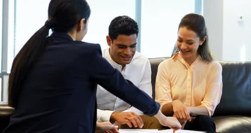 Couple Reviews Documents in a Bright Office