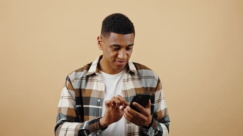 Man Celebrates Success on Smartphone Device