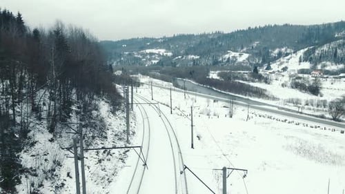 Aerial Flight Over the Tourist Train Route in the Winter Mountains