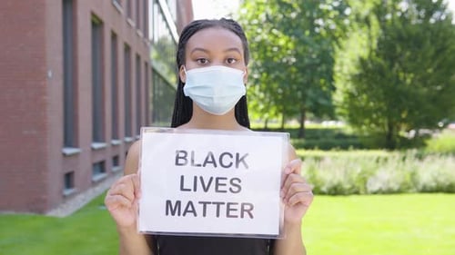 Young Adult Holding a Sign Outdoors
