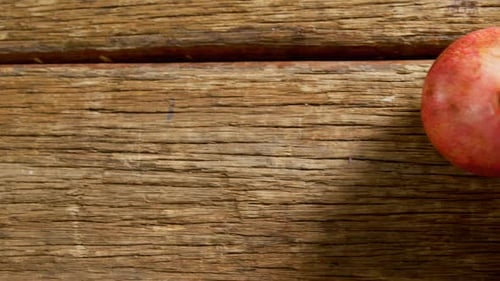 Zwei Granatäpfel auf einem Holztisch 4k