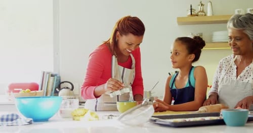 Glückliche Mehrgenerationen-Familie bereitet Lebkuchen in der Küche zu 4k