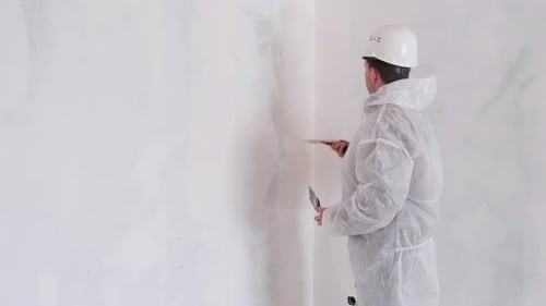 Adult Plastering Wall in Minimalist White Room
