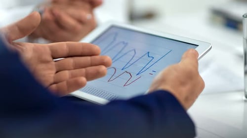 Tablet Shows Business Data in Workplace Meeting