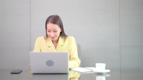 Young Woman Excited While Using Laptop at Work