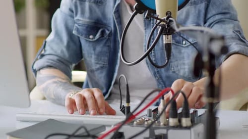 Musician Using Mixing Console and Computer in Home Studio