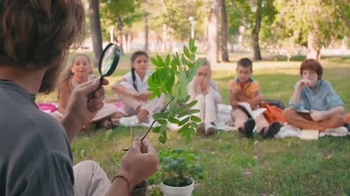 Instructor Demonstrates Leaf to Children in Park Setting