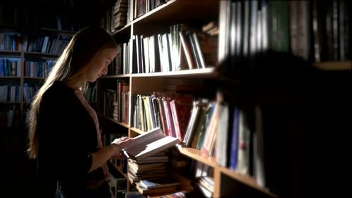 Pretty Young College Student in a Library, Chooses a Book. Close Up