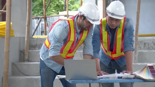 Young Asian engineers and caucasian engineer colleagues at site inspector and discuss together
