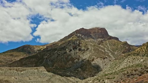 Timelapse Clouds Swirl Over a Green Mountain Valley