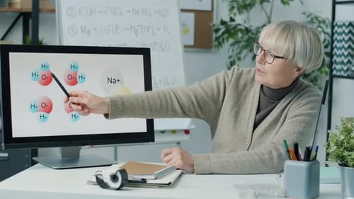 Mature Woman Teaching Science Lesson with Molecule Diagrams