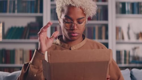 Young Woman Opens Box and Browses Phone