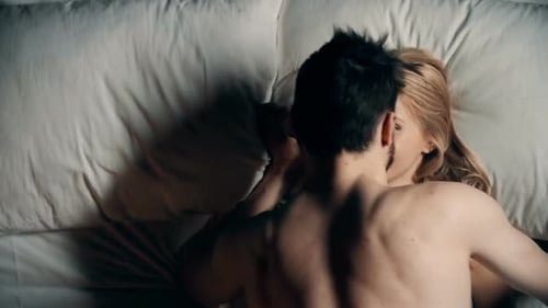 Young Adult Couple Kissing in Bed