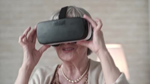 Senior Woman Experiencing Virtual Reality Headset Indoors