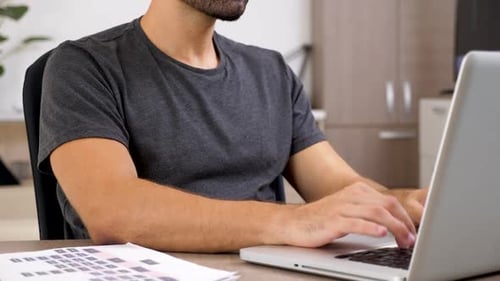 Nahaufnahme von nicht wiederzuerkennenden Menschenhänden beim Tippen auf der Laptoptastatur