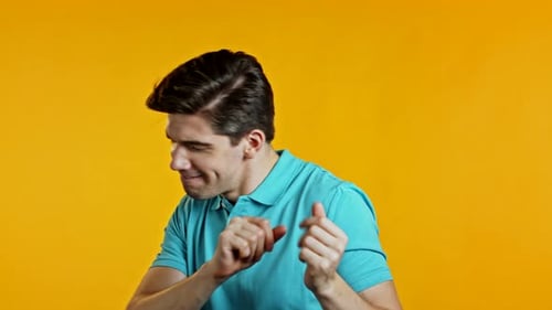 Young Man Dancing Happily Against Yellow Background