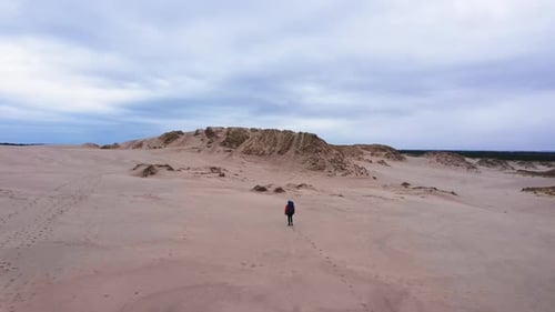 Person Hiking Across Arid Desert Landscape
