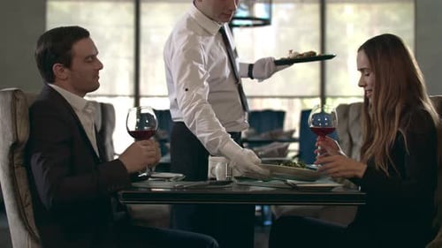 Happy Couple Toasting with Red Wine Glass at Restaurant