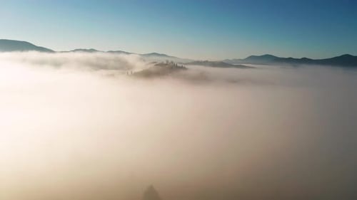 Luftaufnahme des nebligen Sonnenaufgangs in den Bergen