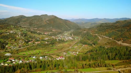 Drone Flying Forward Over Village Surrounded the Pine Forest