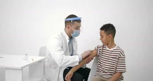 Doctor Administers Vaccination to a Boy