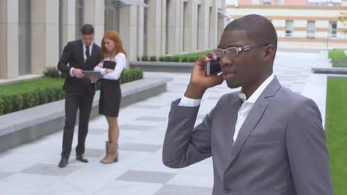 Group Of Happy Multiracial Businesspeople. African American Speaking on the Phone