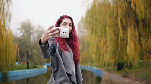 Stylish Woman Taking Selfie in Autumn Park