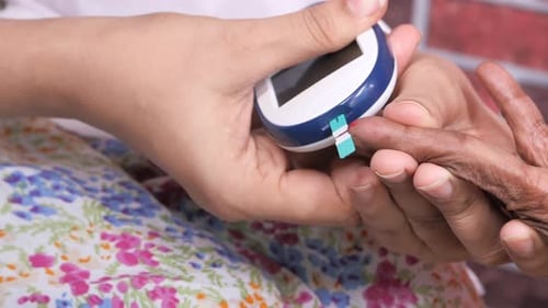 Female Doctor Examining Senior Women Blood Sugar
