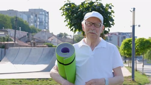 Senior in the morning park with summer sun, retired sport.