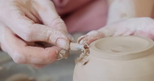 Potter Shaping Clay with a Tool Close Up