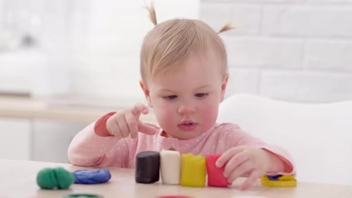 Cute Infant Plays with Colorful Modeling Clay