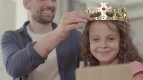 Child Receiving Golden Crown from Parent