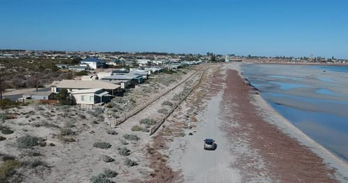 Une voiture longe North Beach à Wallaroo, en Australie-Méridionale, avec des maisons d'un côté et l'océan