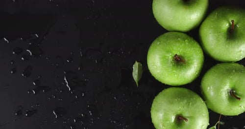 Regentropfen fallen auf frische grüne Äpfel.